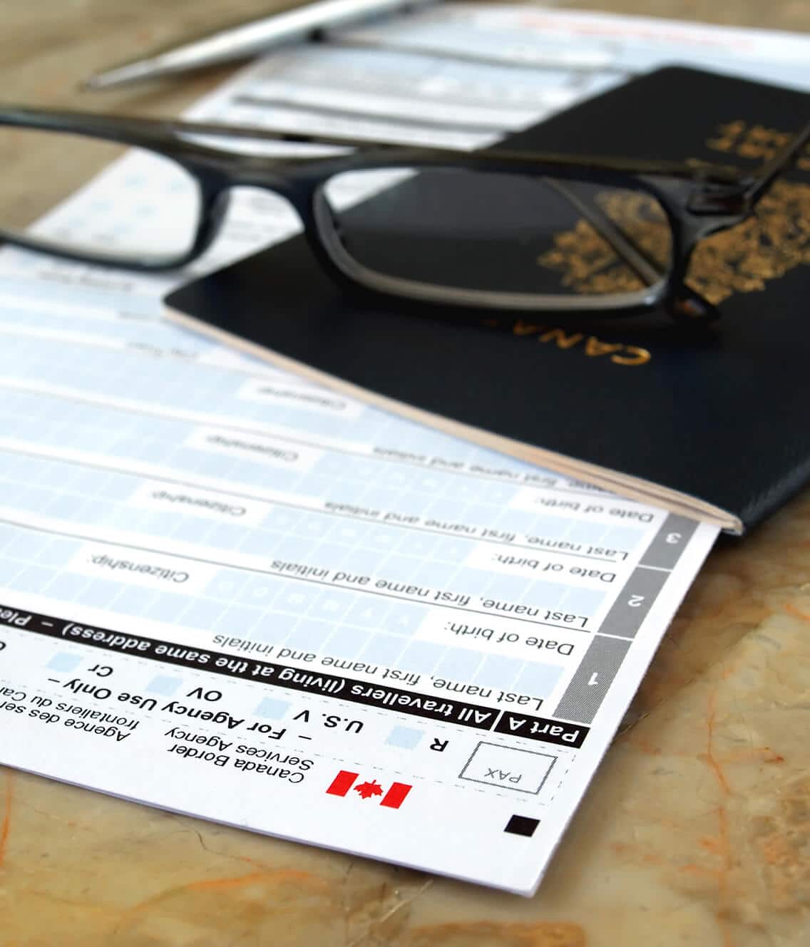 Immigration documents folded in Canadian passport under glasses