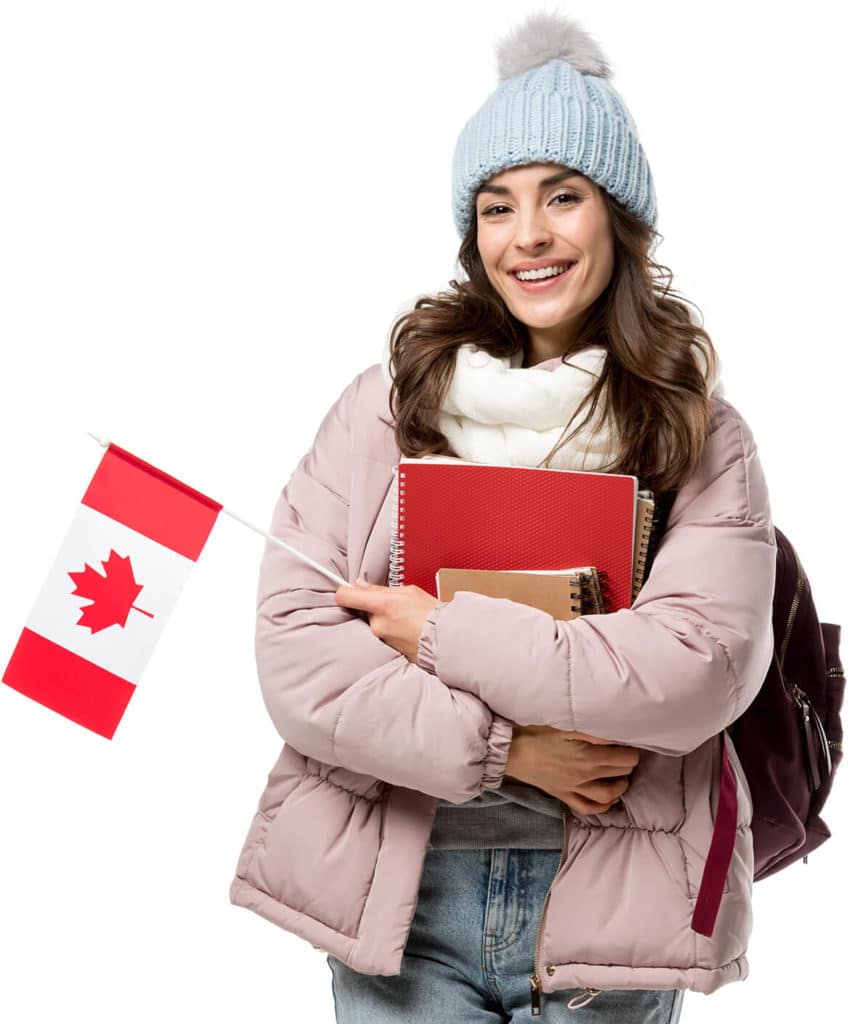 Smiling internation student in winter hat and jacket holding Canadian flag