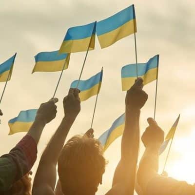 Ukrainian waving their flag in a sunset