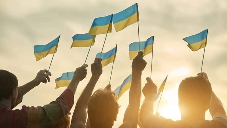 Ukrainian waving their flag in a sunset