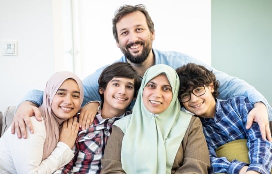 happy muslim family portrait on sofa