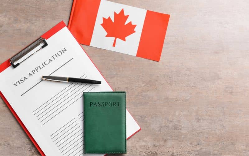 visa application form passport and canadian-flag on table concept of immigration