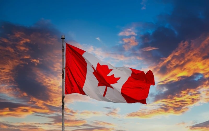 canadian flag flying at sunset