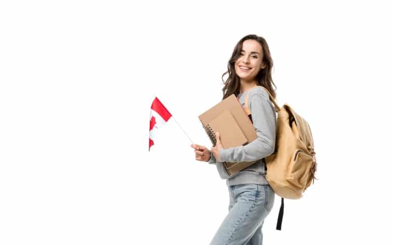 happy female student backpack notebooks looking-camera-while holding canadian