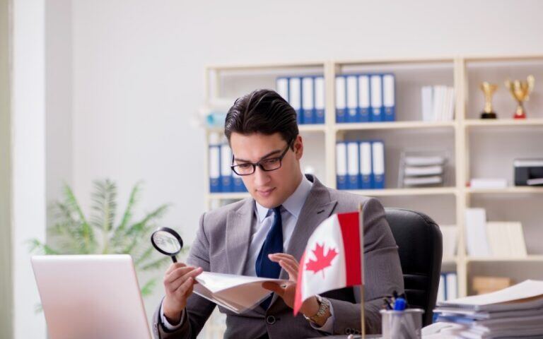 Businessman Holding Canadian Flag in Office - Business Immigration