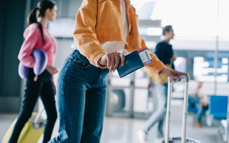 cropped shot girl holding-passport boarding pass airport