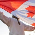 the flag of canada in the-hands-of-a-person-canadian-symbol against the backdrop