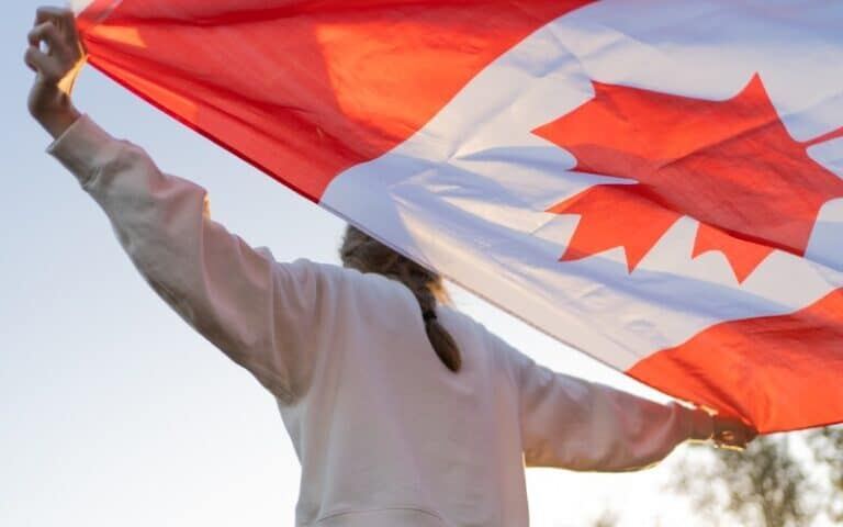 Canadian Flag in Hands of Person - Canada Immigration