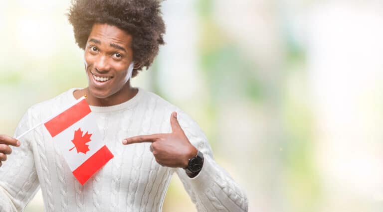 Happy man holding Canada flag and pointing enthusiastically